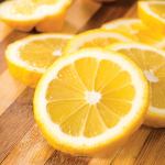 lemon essential oil Fresh lemon slices on wooden cutting board