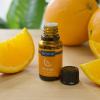 Orange essential oil bottle with fresh orange slices