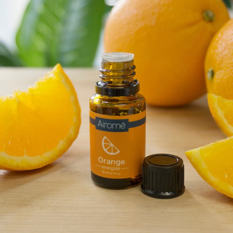 Orange essential oil bottle with fresh orange slices