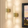 Modern brass wall sconces with glowing glass tubes