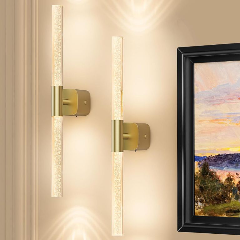 Modern brass wall sconces beside framed artwork