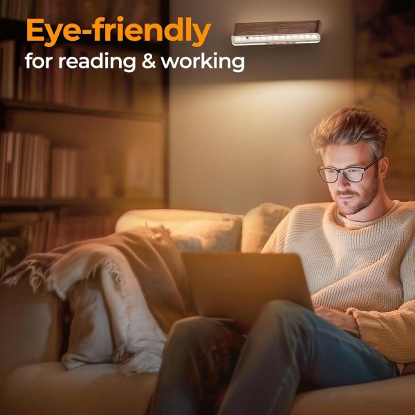 Man using laptop under eye-friendly wall light