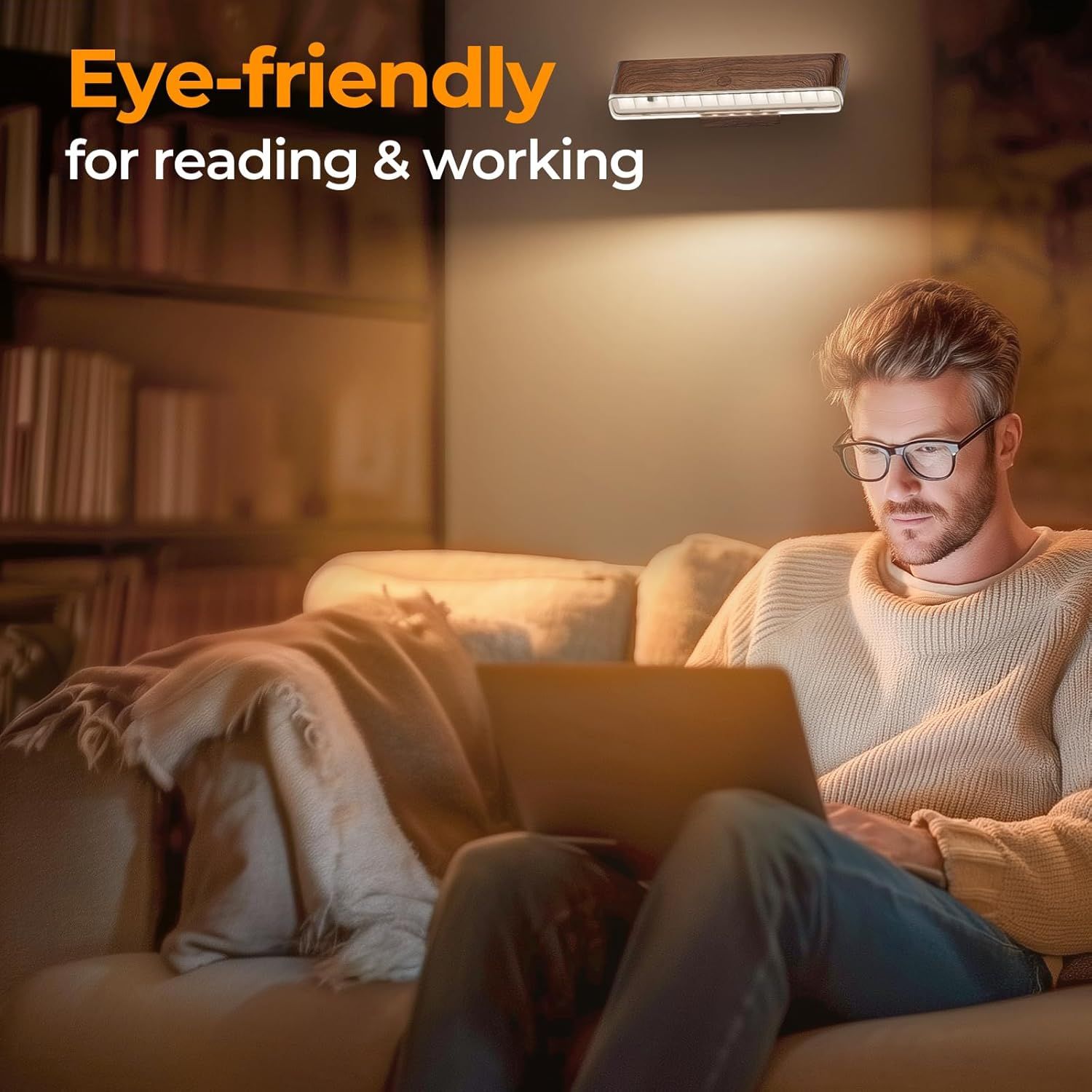 Man using laptop under eye-friendly wall light