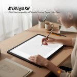 Artist using A3 LED light pad for tracing