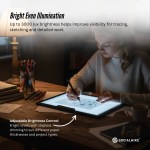 Artist using illuminated light pad for detailed tracing