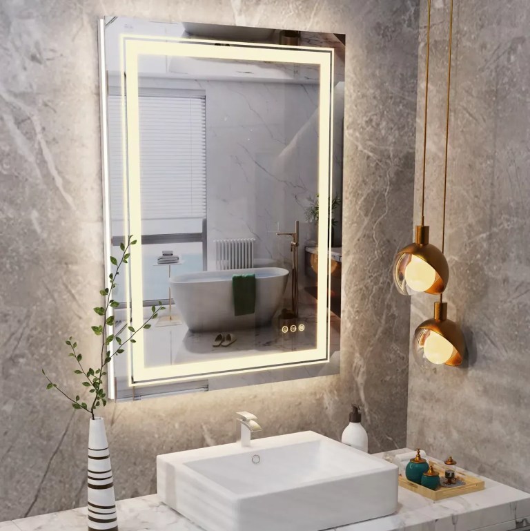Modern bathroom with LED-lit mirror and marble walls