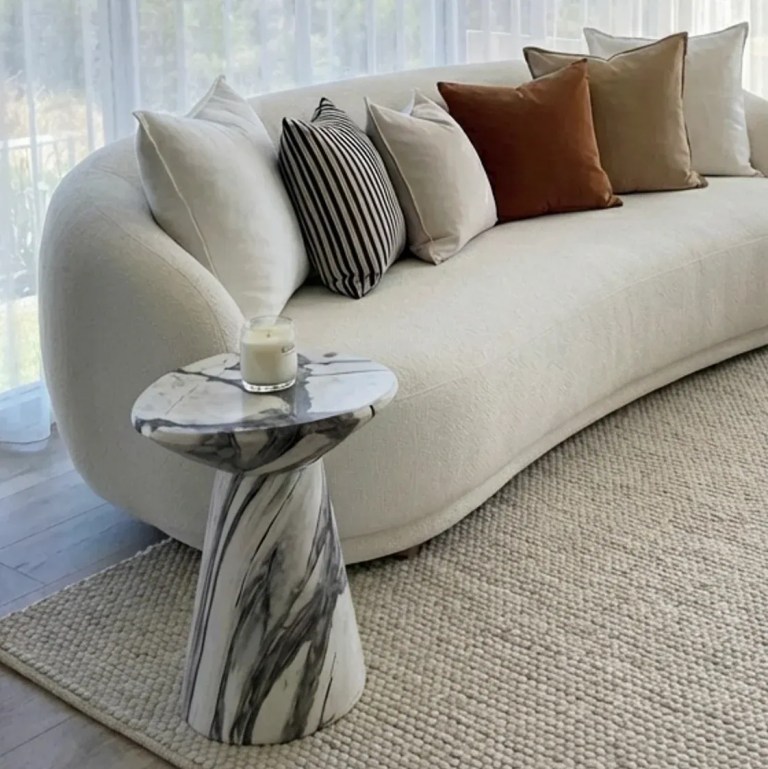 v355 ia st ven pan 00.webp Curved cream sofa with cushions and marble side table