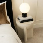 Modern bedside table with globe lamp and books