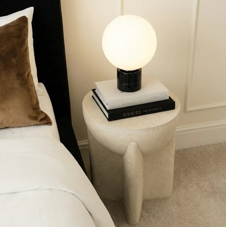 Modern bedside table with globe lamp and books