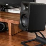 Black studio monitor speaker on wooden desk