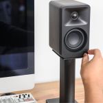 Hand adjusting volume on desktop speaker