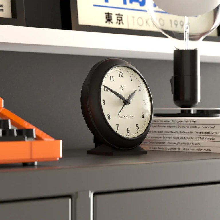 newgate pacific mantel clock black Black analogue clock on shelf beside books