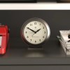 Round Newgate clock on shelf showing ten past ten
