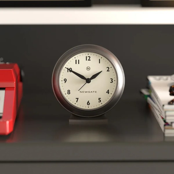 Round Newgate clock on shelf showing ten past ten