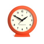 Orange Newgate analogue clock showing 10:10