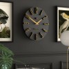Modern black wall clock with gold details