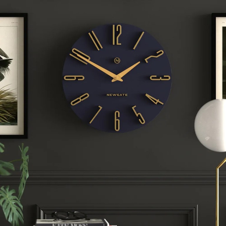 Modern navy and gold wall clock on dark wall
