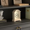 White mantel clock on dark wooden shelf