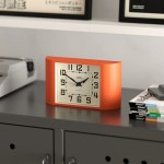 Orange retro mantel clock on modern cabinet