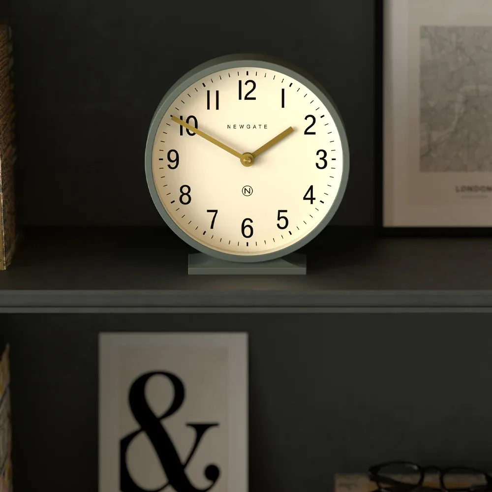 Round white clock on dark shelf at 10:10
