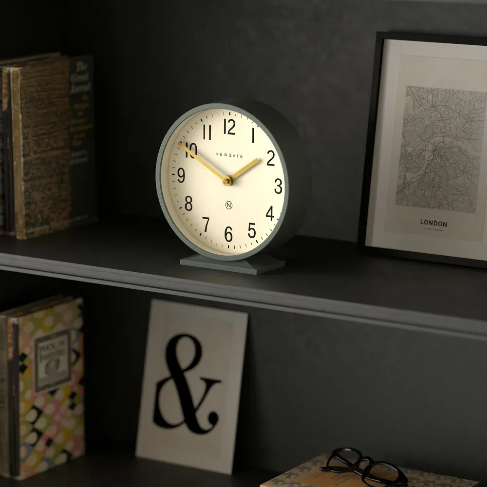 Modern desk clock on shelf with books