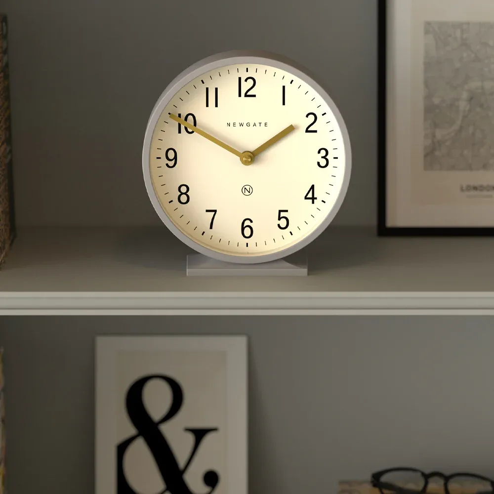 Round white wall clock on shelf