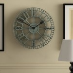 Large vintage metal wall clock on beige wall