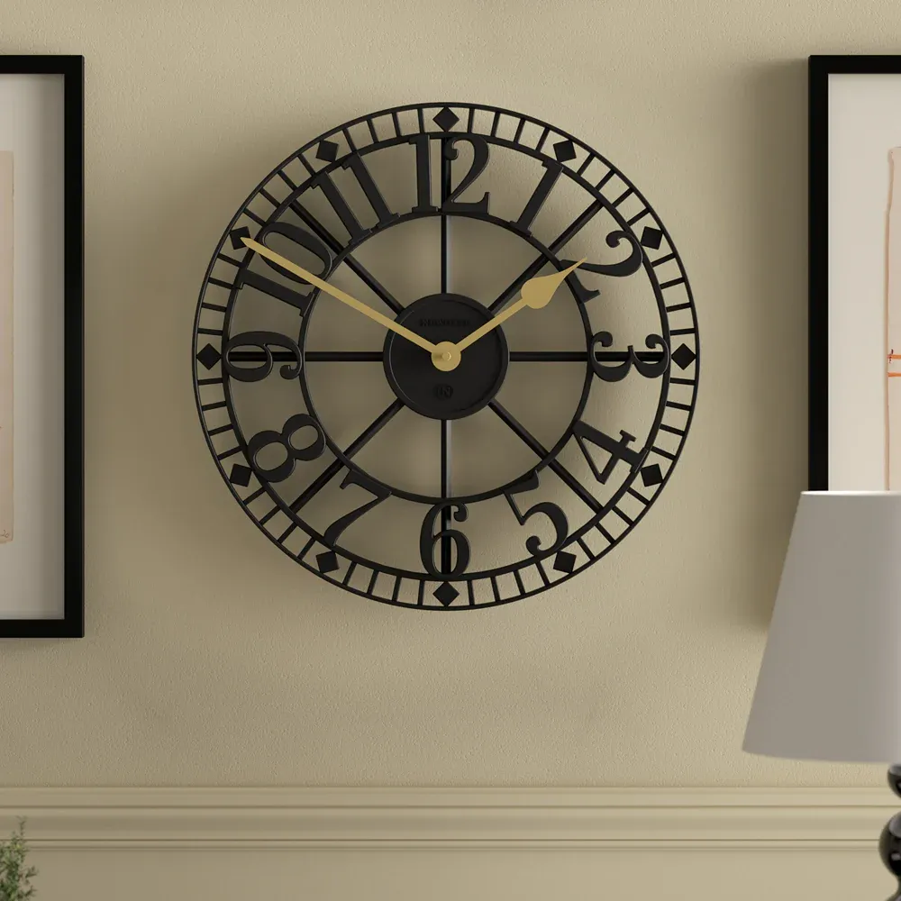 Large black metal wall clock with gold hands
