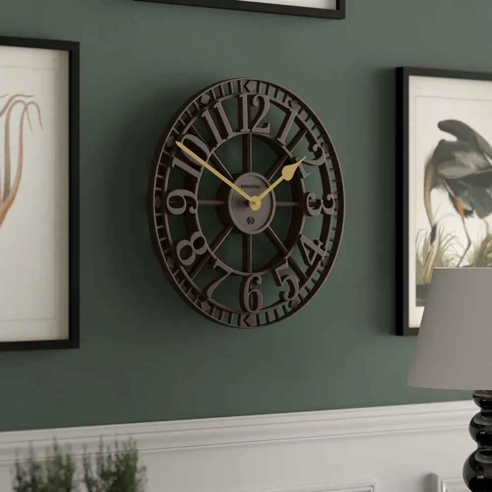 Large black metal wall clock on green wall