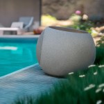 victrola zen premium solar garden speaker Stone-look outdoor speaker beside swimming pool
