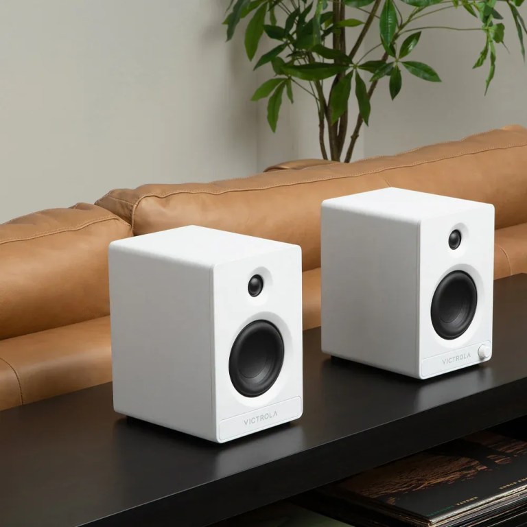 victrola automatic turntable + victrola tempo bookshelf speakers bundle white Two white bookshelf speakers on black table