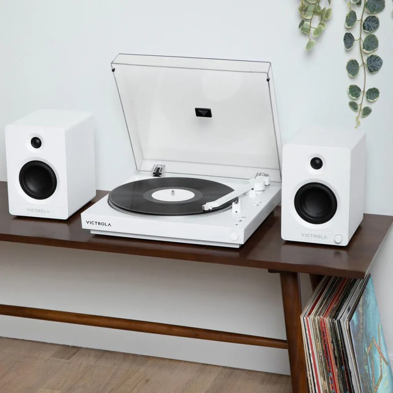 White turntable with speakers on wooden table