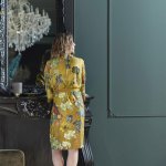 Woman in yellow floral robe by mirror