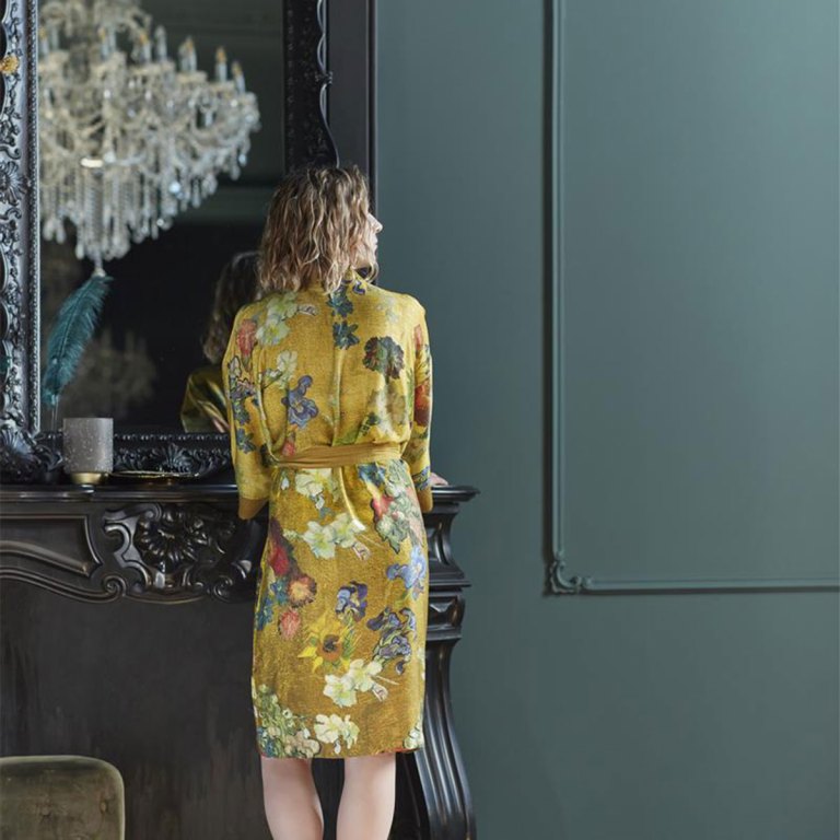 Woman in yellow floral robe by mirror