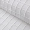 Close-up of white quilted fabric with grid stitching