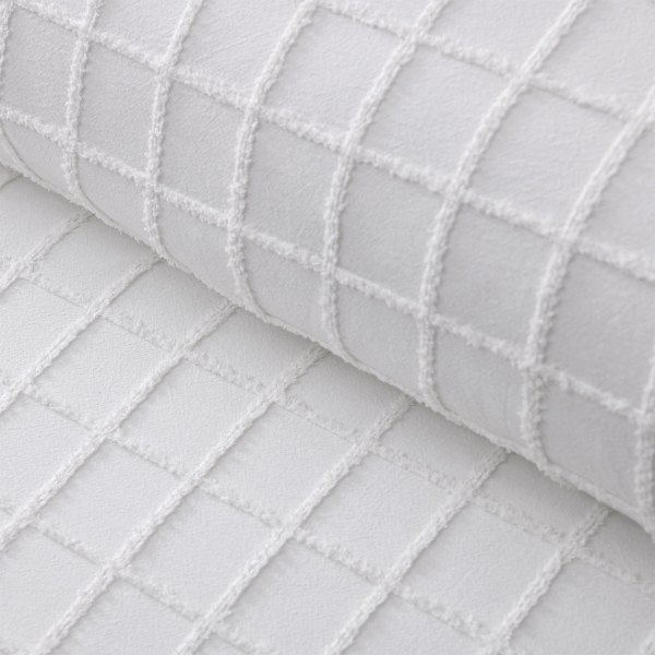 Close-up of white quilted fabric with grid stitching