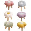Six pastel flower-shaped stools with wooden legs