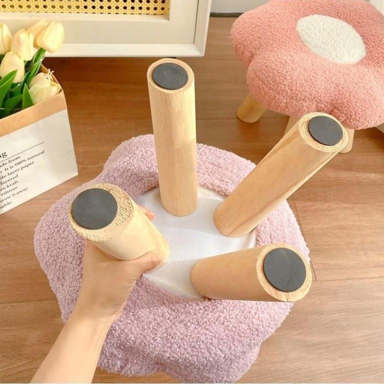 Upside-down pink stool with wooden legs