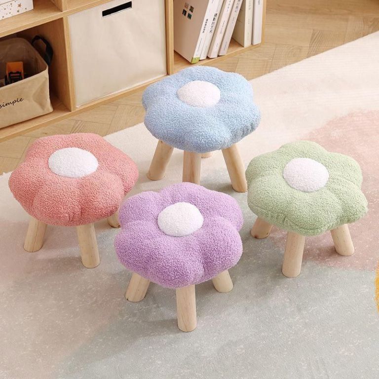 Pastel flower-shaped stools with wooden legs indoors