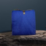 Blue canvas bag with leather strap on stone
