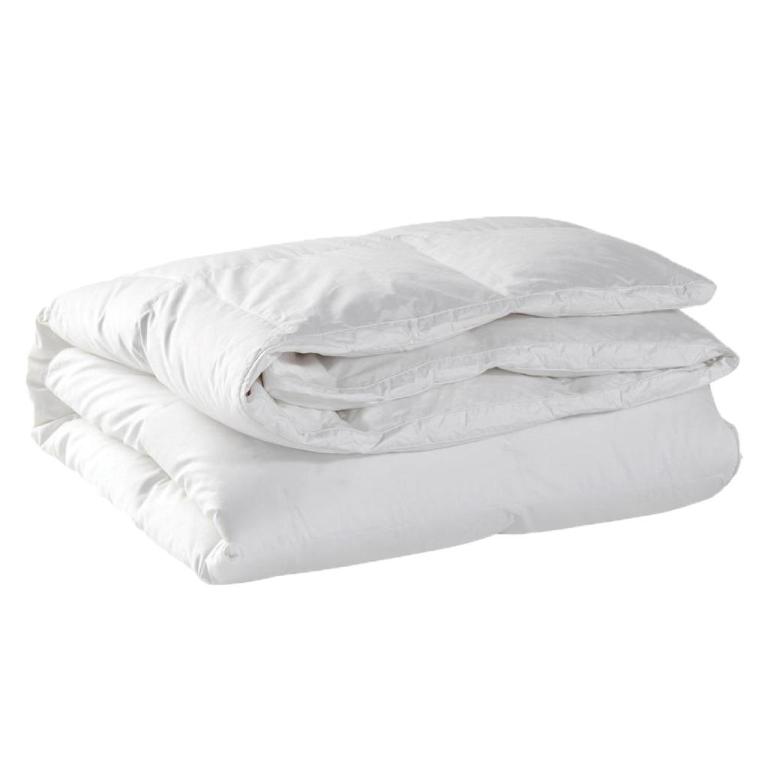 Folded white quilt and pillows on white background