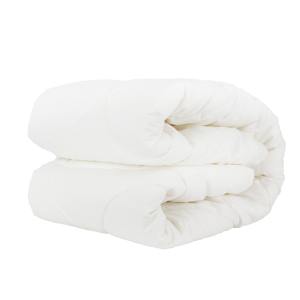 Folded white quilt on white background