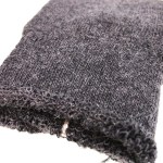 Close-up of grey knitted fabric with frayed edge