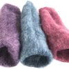 Three colourful fluffy wool slippers on white background