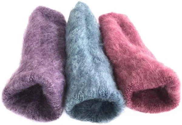 Three colourful fluffy wool slippers on white background