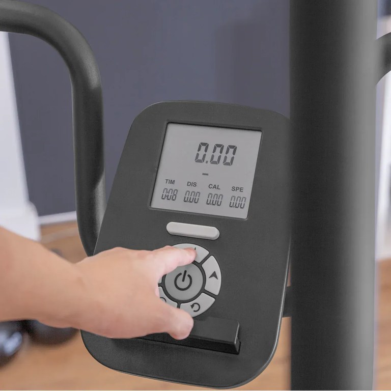 Hand pressing button on exercise machine console