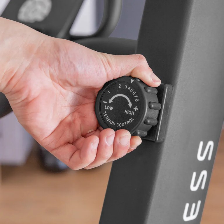 Hand adjusting exercise bike tension control knob