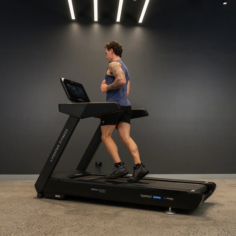 Man running on treadmill in modern gym
