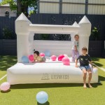 Children playing in white backyard jumping castle