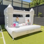 Children playing in white inflatable bouncy castle outdoors